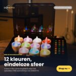 Een open doos toont 12 oplaadbare, waterdichte RGB LED-Waxine/theelichtjes (tot 160 uur) plus afstandsbediening. Ervaar eindeloze sfeer met Dorsettos 12-kleuren LED kaarsen-shop nu!.