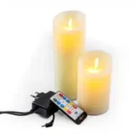 De Oplaadbare LED wax kaarsen set van 2 DORSETTO gloeit zacht naast een afstandsbediening en plug-in lader, weergegeven op een witte achtergrond.