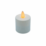 Het LED waxine kaarsje oplaadbaar DORSETTO warm wit met bewegende vlam LOS is een klein, wit, cilindervormig waxinelichtje met een gloeiende, vlamvormige gele punt, afgebeeld tegen een effen witte achtergrond.