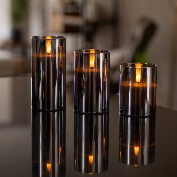 Drie glazen kandelaars met de DORSETTO oplaadbare led kaarsen set 105 uur (3D vlam, met afstandsbediening) creëren een warme gloed en luxe sfeer voor een ontspannen avond of bijzondere gelegenheid.
