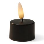 Een klein, zwart LED waxinelichtje op batterijen met een plastic vlam die een warme, gelige gloed afgeeft.