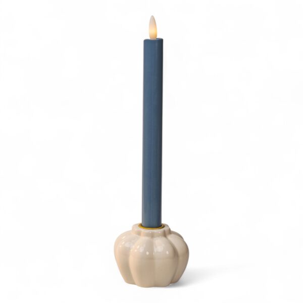 Een verlichte, hoge donkergrijze LED dinerkaars (250 mm, oplaadbaar, 400 branduren) staat in een ronde, crème keramische houder met een geribbeld ontwerp tegen een effen witte achtergrond.